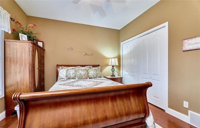 bedroom featuring hardwood / wood-style floors, ceiling fan, and a closet