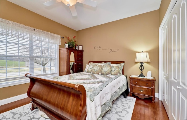 bedroom with dark hardwood / wood-style flooring and ceiling fan