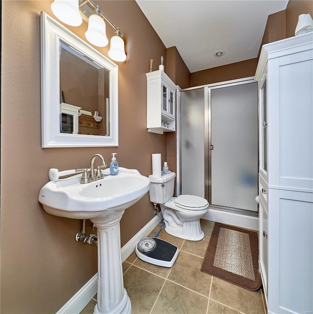 bathroom featuring tile patterned flooring, a shower with door, and toilet