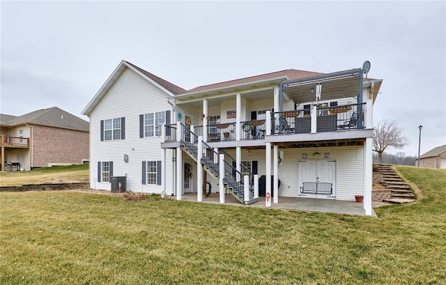 back of house featuring a deck, a patio area, and a lawn