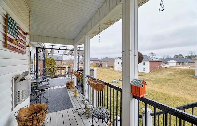 wooden deck featuring covered porch and a lawn