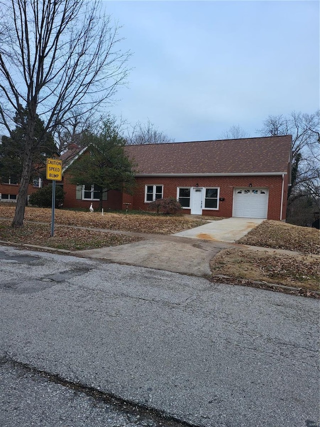 ranch-style house featuring aphalt driveway, brick siding, an attached garage, and roof with shingles