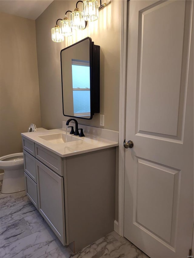 bathroom featuring toilet, marble finish floor, and vanity