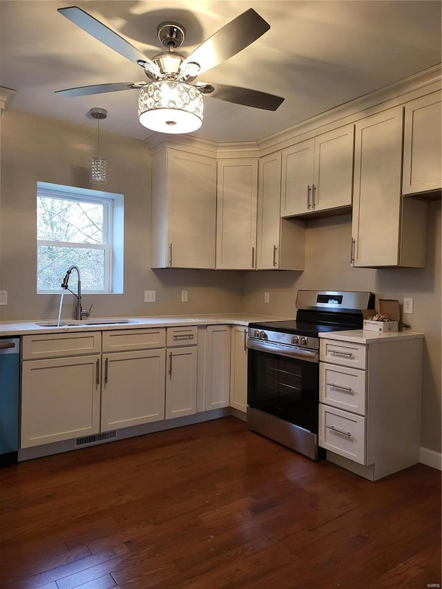 kitchen with electric range, visible vents, dark wood finished floors, light countertops, and a sink