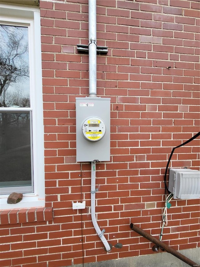 exterior details featuring electric meter and brick siding