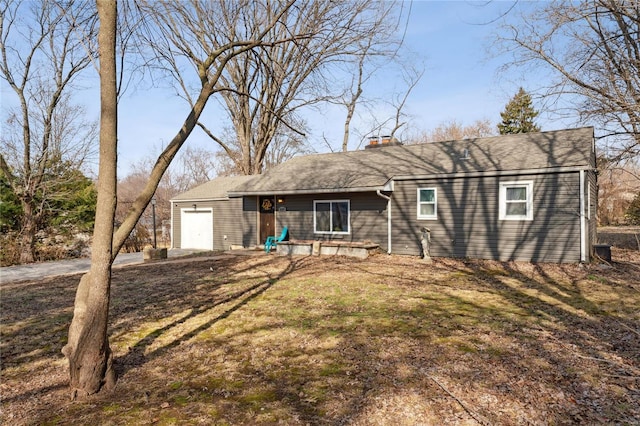 rear view of house with a garage and a lawn