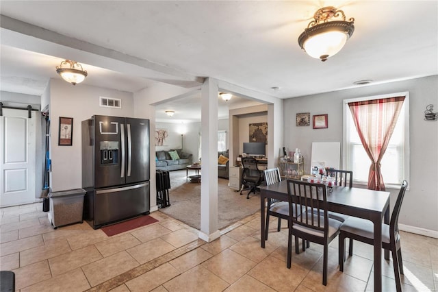 tiled dining room featuring a barn door