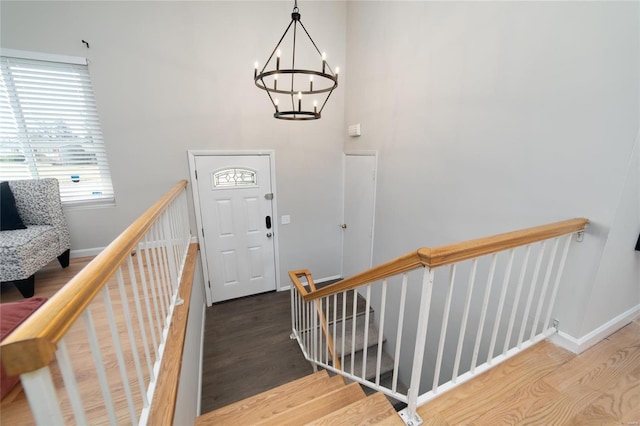 foyer entrance with an inviting chandelier and wood-type flooring