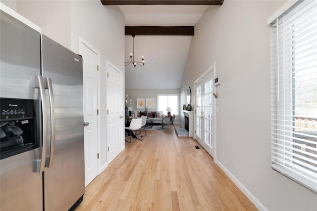 kitchen featuring high vaulted ceiling, beamed ceiling, a chandelier, stainless steel refrigerator with ice dispenser, and light wood-type flooring