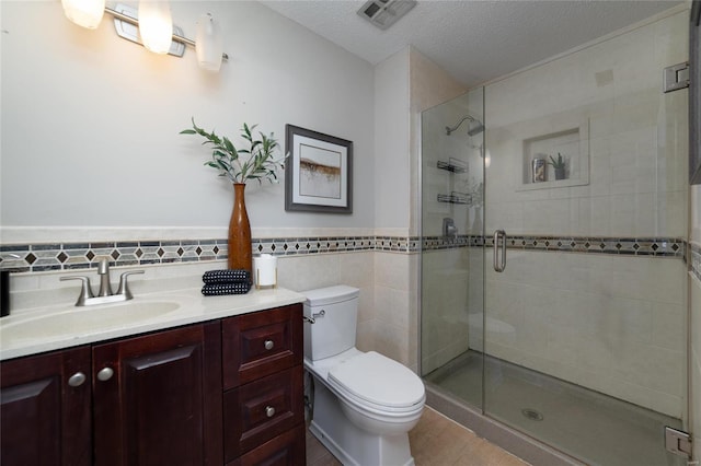 bathroom featuring walk in shower, toilet, tile walls, a textured ceiling, and vanity