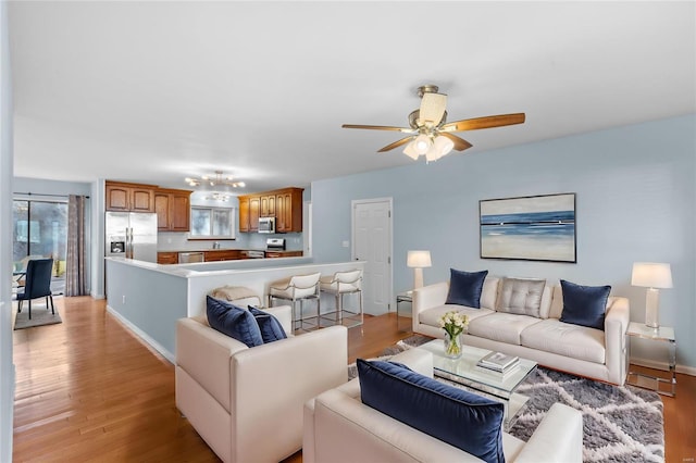 living room featuring ceiling fan and light hardwood / wood-style flooring