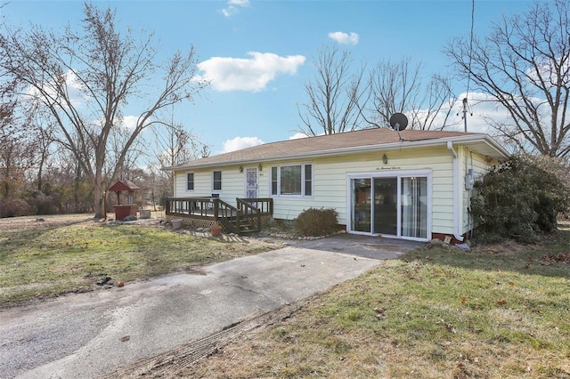 rear view of property with a yard and a deck