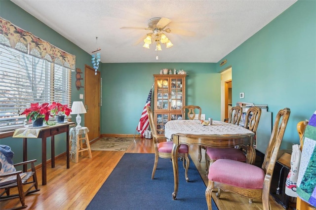 dining area featuring a textured ceiling, ceiling fan, and light wood-type flooring