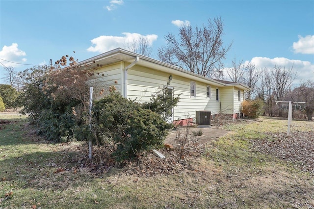 view of property exterior with central AC unit and a lawn