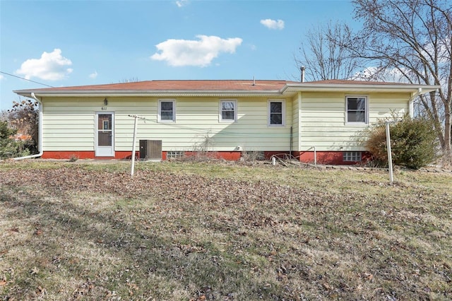 back of property with central AC and a yard