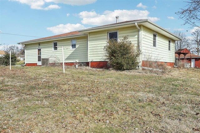 rear view of house featuring a yard