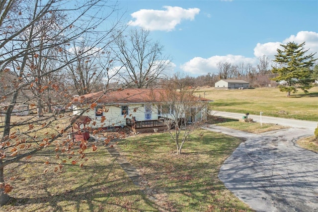 view of front of house with a deck and a front lawn