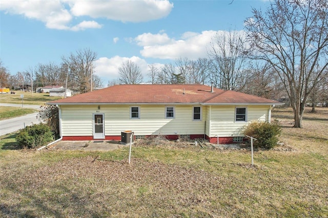 back of property with cooling unit and a yard