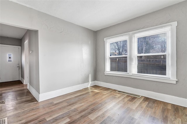 spare room with hardwood / wood-style floors and a textured ceiling