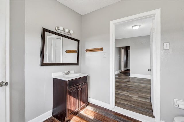 bathroom featuring hardwood / wood-style flooring, vanity, and a textured ceiling