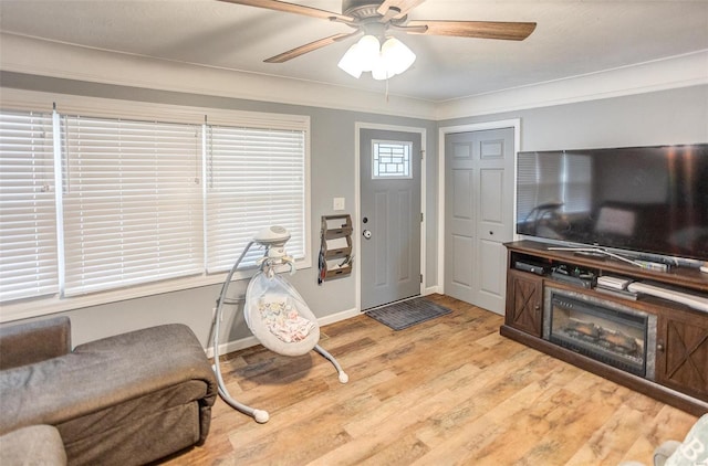 interior space featuring crown molding, ceiling fan, and light hardwood / wood-style flooring