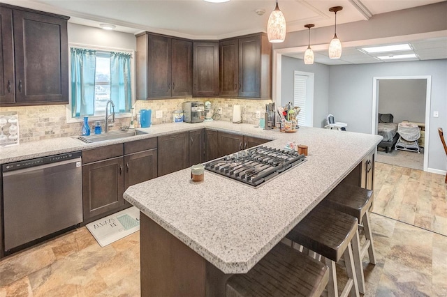 kitchen with dark brown cabinetry, sink, a breakfast bar area, decorative light fixtures, and appliances with stainless steel finishes