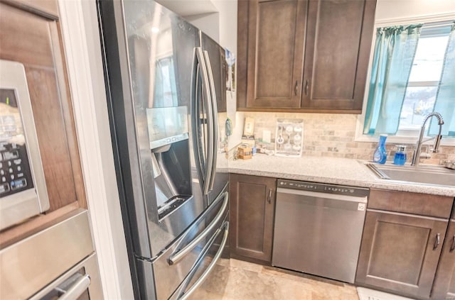 kitchen featuring sink, decorative backsplash, dark brown cabinets, and stainless steel appliances