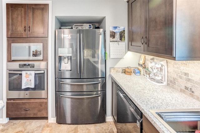 kitchen with dark brown cabinets, appliances with stainless steel finishes, light stone countertops, and decorative backsplash