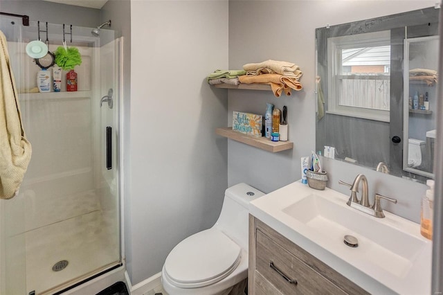 bathroom with vanity, toilet, and a shower with shower door