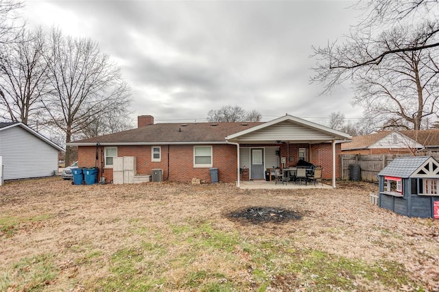 back of house featuring a yard, central AC unit, and a patio