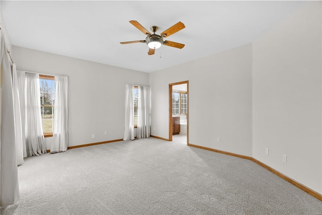 carpeted spare room with ceiling fan