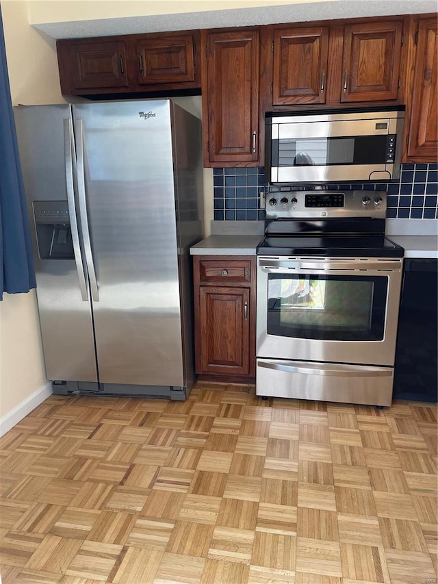 kitchen featuring backsplash, appliances with stainless steel finishes, and light countertops