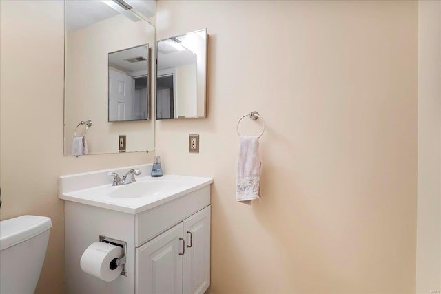 bathroom with visible vents, toilet, and vanity