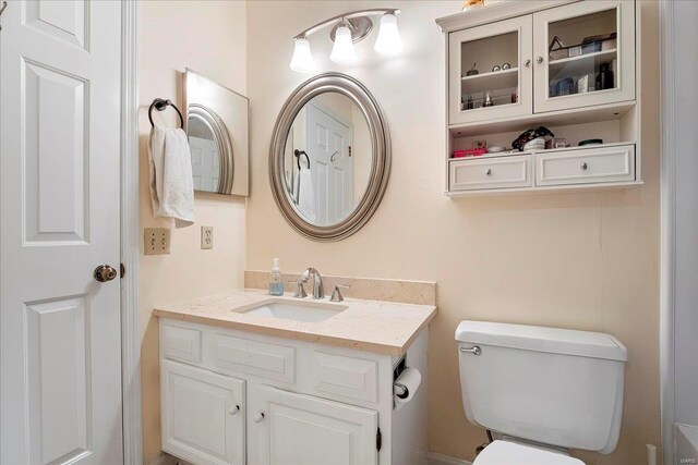 half bath featuring toilet and vanity