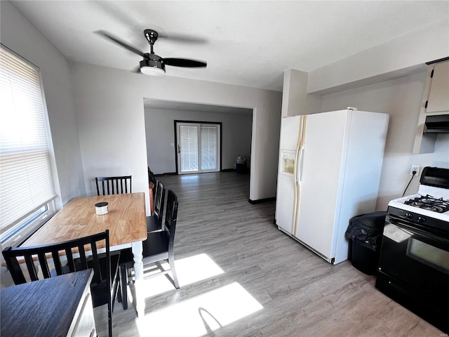 dining space with ceiling fan and light wood-type flooring