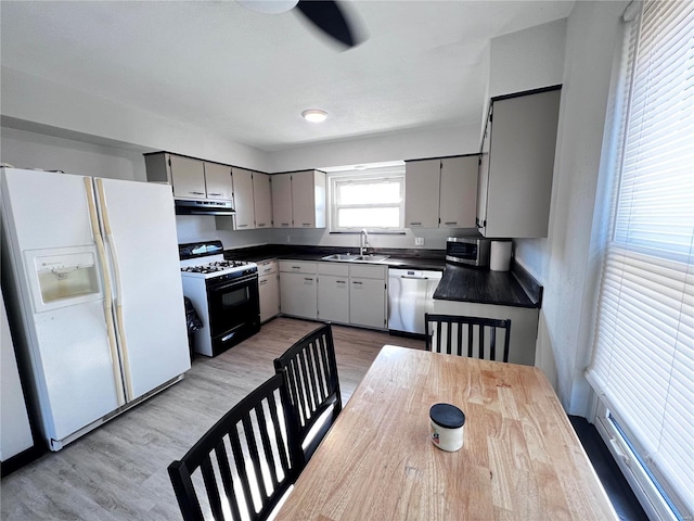 kitchen with gray cabinetry, range with gas stovetop, white fridge with ice dispenser, and dishwasher