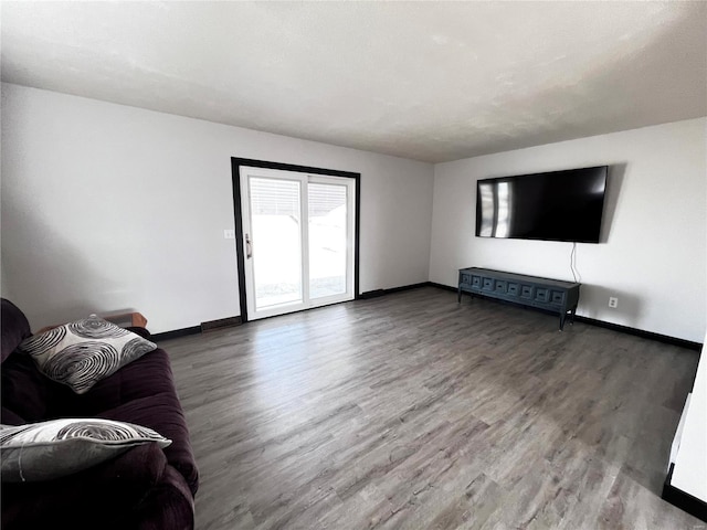 unfurnished living room featuring baseboards and wood finished floors