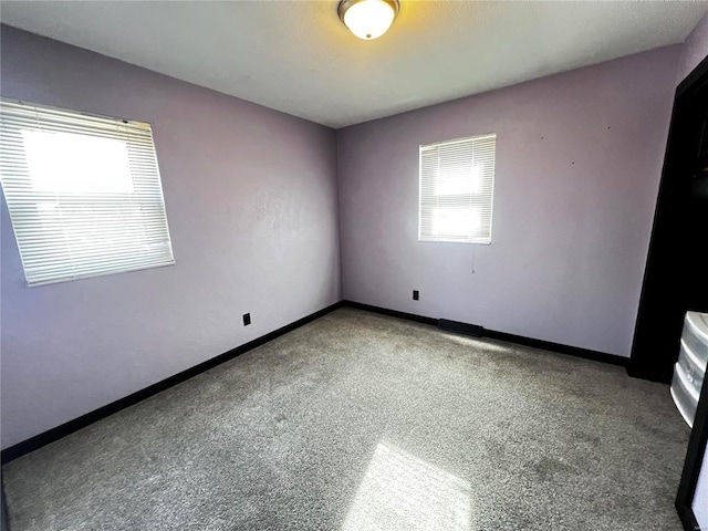 carpeted spare room with baseboards