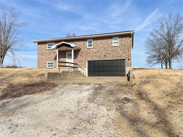 bi-level home with brick siding, driveway, and an attached garage