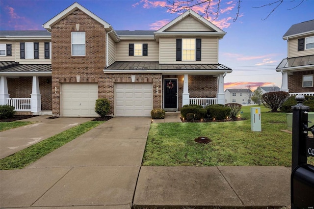 view of property featuring a yard, a garage, and covered porch