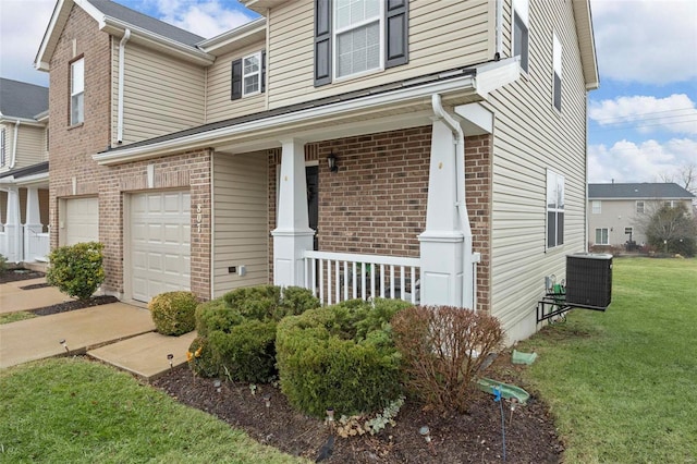 view of front of home featuring cooling unit, a garage, a front lawn, and a porch