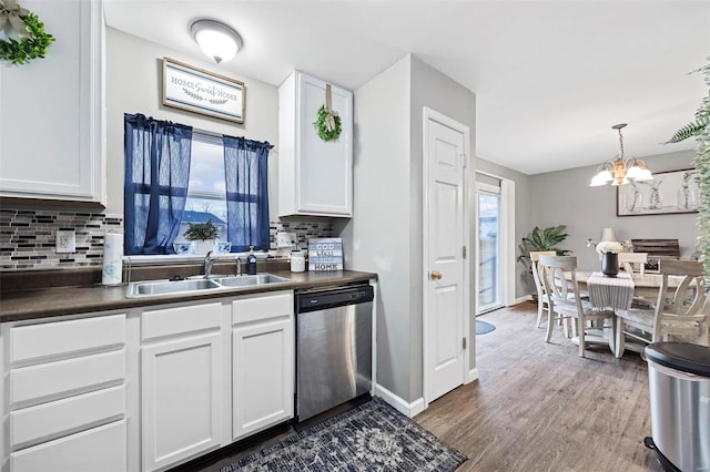 kitchen with dishwasher, sink, pendant lighting, and white cabinets