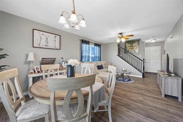 dining room featuring dark wood-type flooring and ceiling fan with notable chandelier