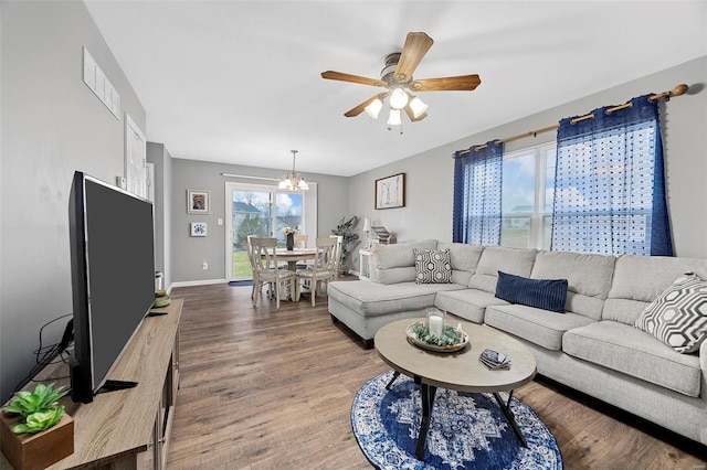 living room featuring wood-type flooring and ceiling fan with notable chandelier