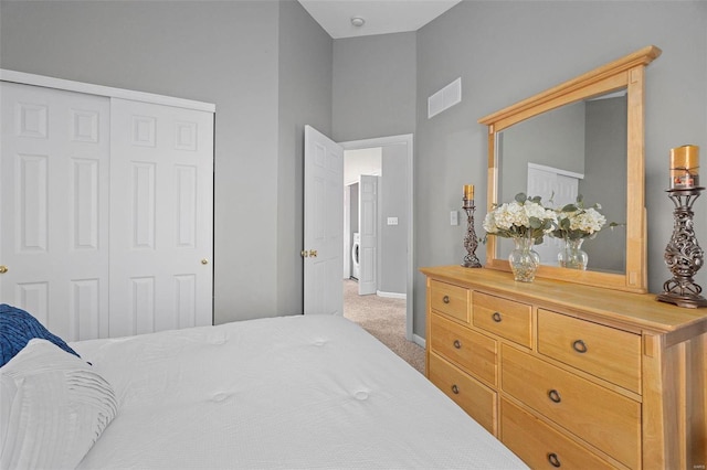 bedroom with washer / dryer, a closet, and carpet flooring