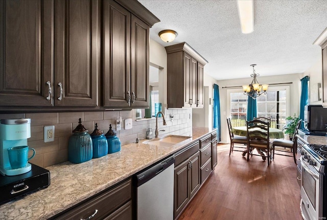 kitchen with dark brown cabinetry, sink, appliances with stainless steel finishes, dark hardwood / wood-style flooring, and decorative backsplash