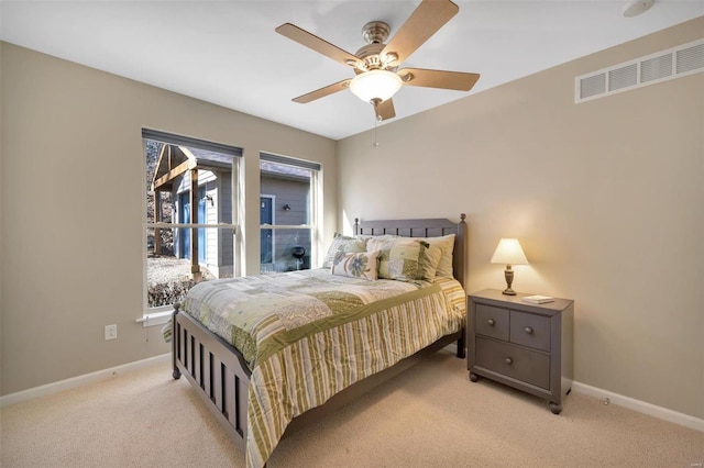 bedroom with baseboards, visible vents, ceiling fan, and light colored carpet