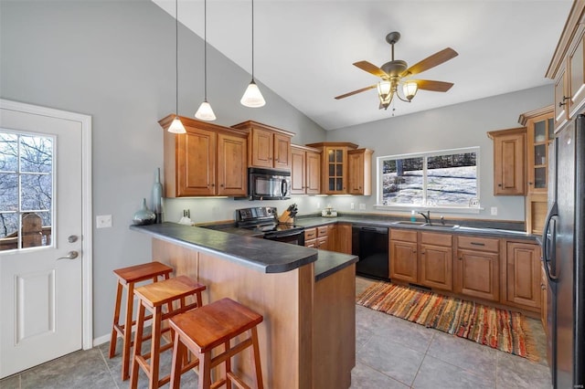 kitchen with a breakfast bar, dark countertops, glass insert cabinets, a sink, and black appliances