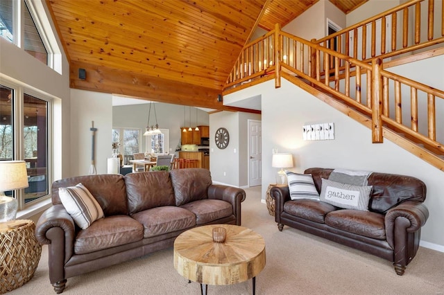 carpeted living area with high vaulted ceiling, wood ceiling, baseboards, and stairs