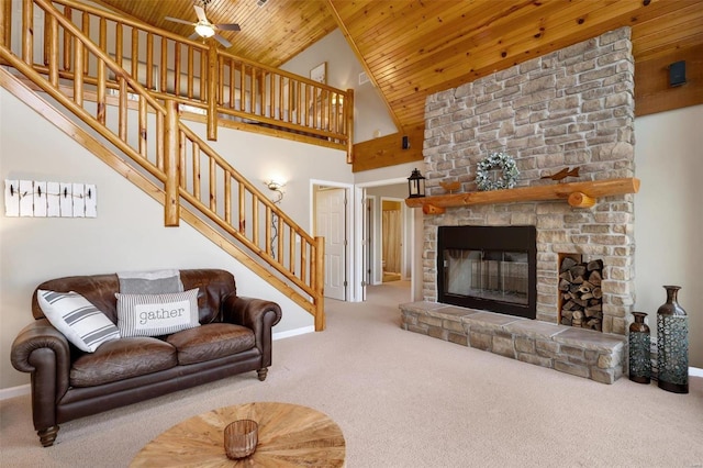 carpeted living room with baseboards, wooden ceiling, stairs, a fireplace, and high vaulted ceiling